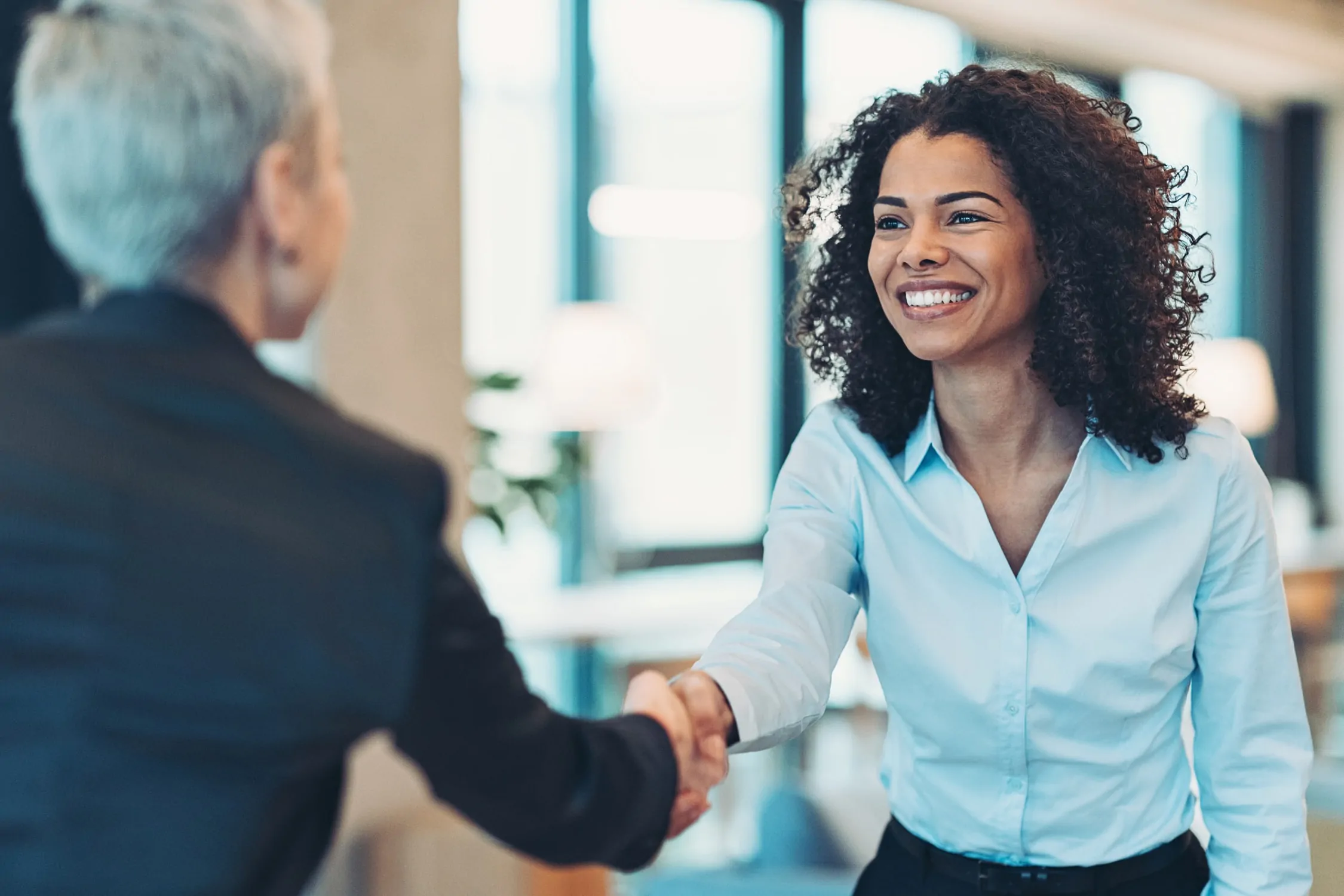 two business women shaking hands, reducing friction in the retailer-vendor relationship