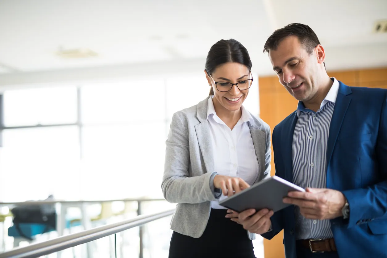 Two business people discussing contract management services using digital tablet